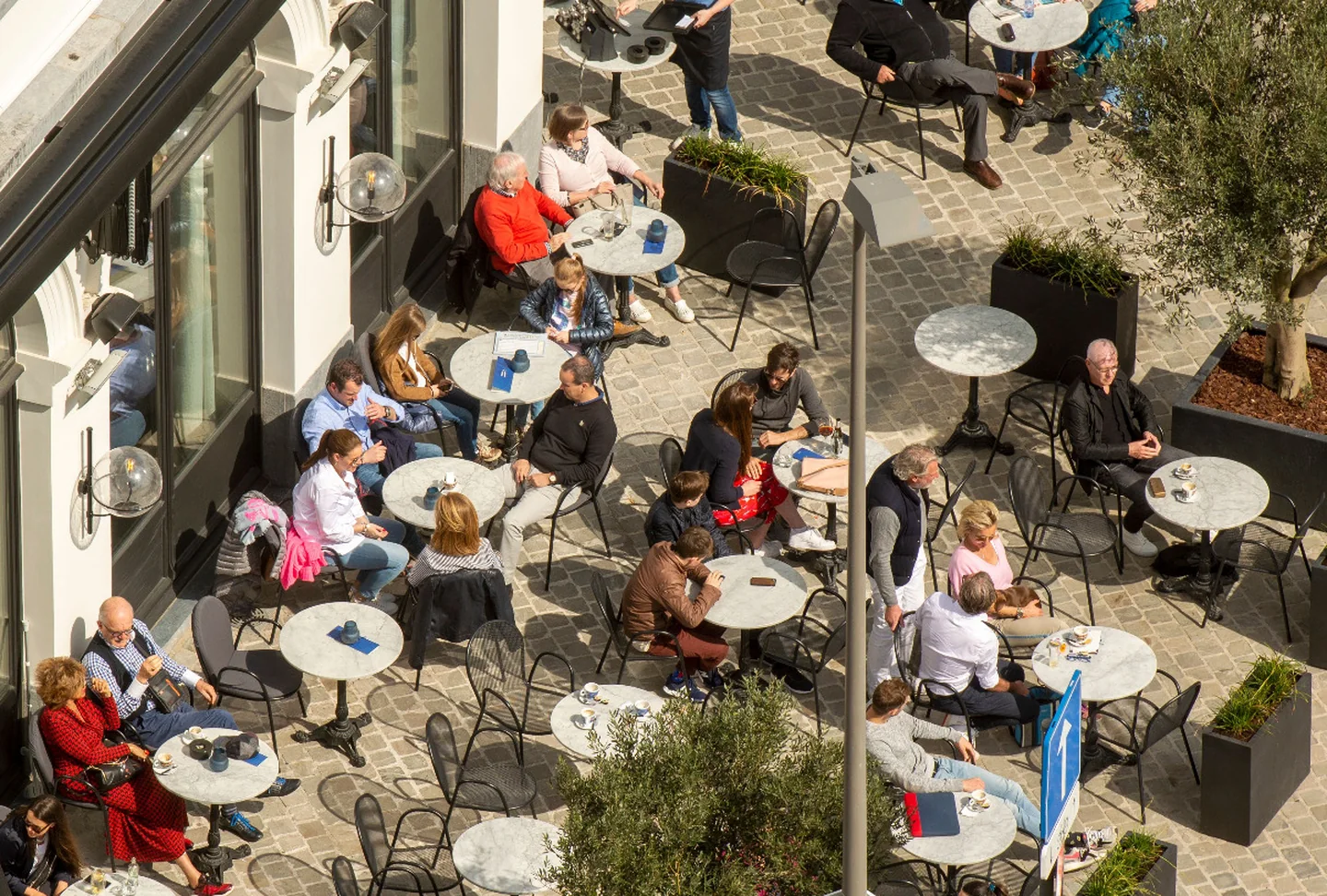 Belebter Innenstadtplatz mit Menschen und Außengastronomie